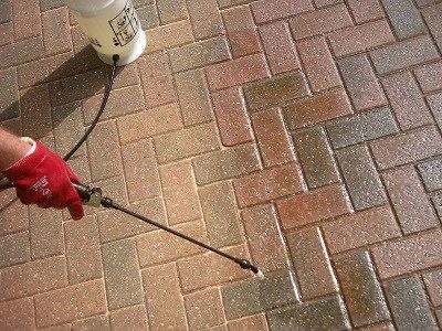 paver sealer being applied with spray method