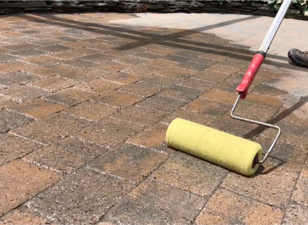 paver sealer being applied with paint roll